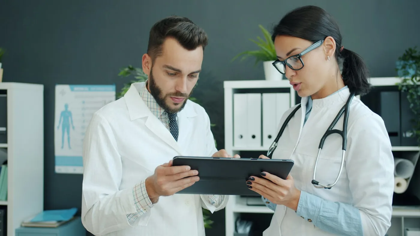 Two doctors reviewing information together on a tablet